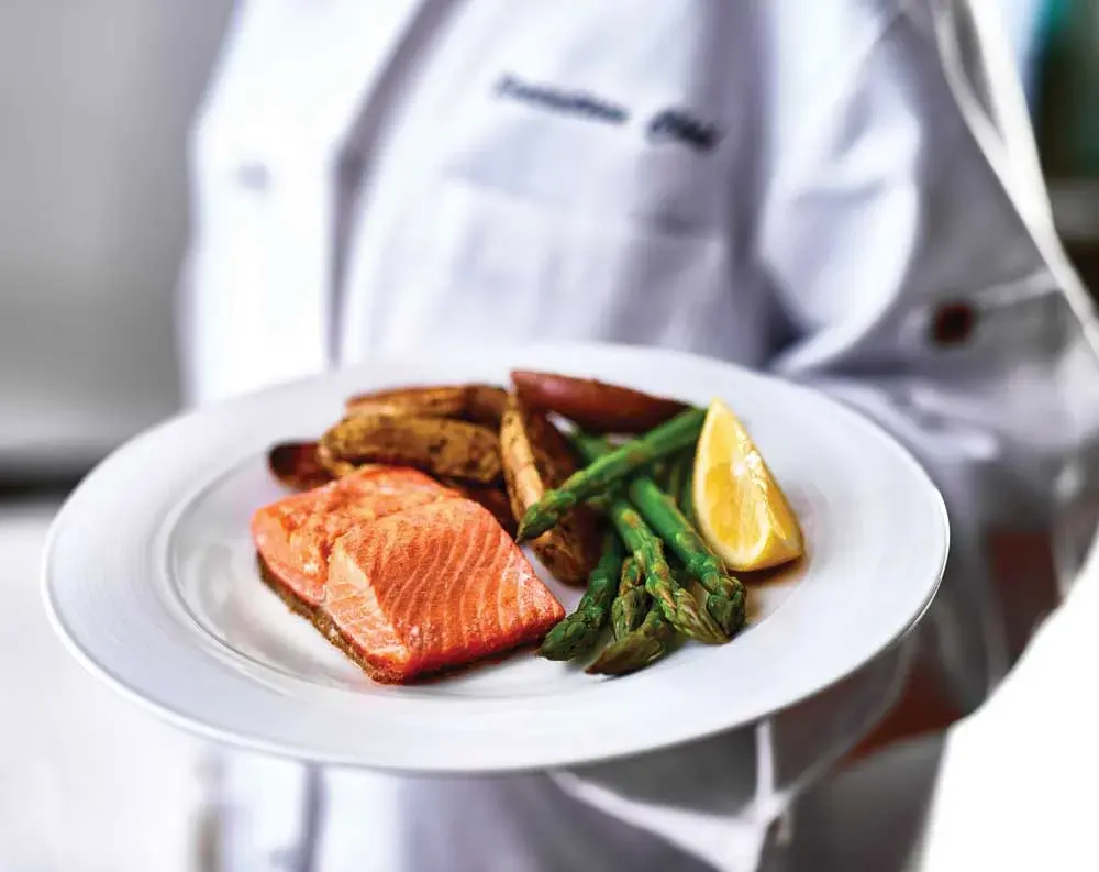 Salishan Chef Created Meals, chef delivering a finished dish.